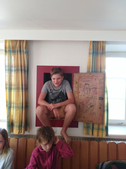 In der Wand ein Schrank - und ein Kind sitzt darin, obwohl es dafür viel zu groß ist
